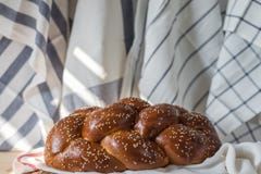 Challahbröd på en träplatta på trätabellen arkivbild Challahbröd på en träplatta på trätabellen arkivbild