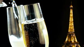 Champagne flutes with golden bubbles on golden glitter sparkle eiffel tower on black night background, holiday christmas stock video footage Champagne flutes with golden bubbles on golden glitter sparkle eiffel tower on black night background, holiday christmas stock video footage