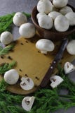 Champignon mushrooms laid out on the board, next to green dill and a knife for cutting. There is open space for text royalty free stock photo Champignon mushrooms laid out on the board, next to green dill and a knife for cutting. There is open space for text royalty free stock photo
