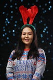 Chandail de Noël de fille asiatique et bandeau de port de klaxons de renne photographie stock libre de droits Chandail de Noël de fille asiatique et bandeau de port de klaxons de renne photographie stock libre de droits