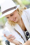 Chapeau blanc de port de jeune femme et écouter la musique images stock Chapeau blanc de port de jeune femme et écouter la musique images stock
