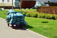 Chariot de jardin avec une pile de paillis mis en sac au moment d'arrière-cour photographie stock libre de droits Chariot de jardin avec une pile de paillis mis en sac au moment d'arrière-cour photographie stock libre de droits