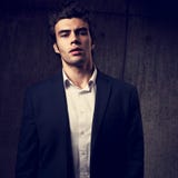 Charismatic sexy man posing in black fashion suit and white styl. E shirt on dark shadow background. Closeup portrait Royalty Free Stock Photography Charismatic sexy man posing in black fashion suit and white styl. E shirt on dark shadow background. Closeup portrait Royalty Free Stock Photography