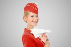Charmante Stewardess Holding Paper Plane ter beschikking Grijze achtergrond royalty-vrije stock foto Charmante Stewardess Holding Paper Plane ter beschikking Grijze achtergrond royalty-vrije stock foto