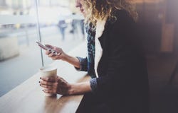 Charmante vrouw met mooie glimlach die mobiele telefoon met behulp van tijdens rust in koffiewinkel Vage achtergrond stock fotografie Charmante vrouw met mooie glimlach die mobiele telefoon met behulp van tijdens rust in koffiewinkel Vage achtergrond stock fotografie