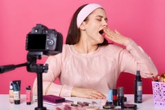 Charmig attraktiv blogger med stängda ögon som åt sidan brett ser, öppnande mun och att täcka den med handen och att ha lust att royaltyfri fotografi Charmig attraktiv blogger med stängda ögon som åt sidan brett ser, öppnande mun och att täcka den med handen och att ha lust att royaltyfri fotografi