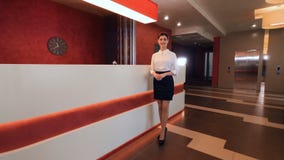 Charming female receptionist in hotel lobby.