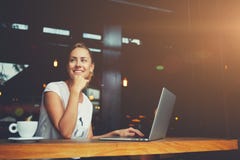 Charming happy woman student using laptop computer to prepare for the course work royalty free stock photography Charming happy woman student using laptop computer to prepare for the course work royalty free stock photography