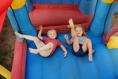 Charming little boy and girl having fun in leisure center for kids. Child sport activity on outdoor playground. Cute children stock images Charming little boy and girl having fun in leisure center for kids. Child sport activity on outdoor playground. Cute children stock images