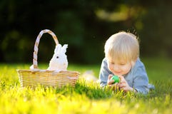 Charming little boy hunting for easter egg in spring park on Easter day Royalty Free Stock Photos Charming little boy hunting for easter egg in spring park on Easter day Royalty Free Stock Photos