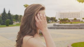 A charming sensual young girl in a summer dress is walking along the park in the center of the city. Her long hair flies stock footage A charming sensual young girl in a summer dress is walking along the park in the center of the city. Her long hair flies stock footage