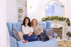 Two cute girlfriends posing with smile and sitting together on c stock images Two cute girlfriends posing with smile and sitting together on c stock images