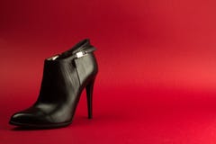 Chaussure noire de talon haut sur le fond rouge Photographie stock Chaussure noire de talon haut sur le fond rouge Photographie stock