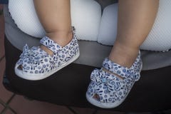 Chaussures de bébé de port de pied de bébé dans la poussette photographie stock Chaussures de bébé de port de pied de bébé dans la poussette photographie stock