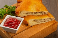 Chebureks сделало дома, кудрявая корка, деревянная предпосылка стоковая фотография Chebureks сделало дома, кудрявая корка, деревянная предпосылка стоковая фотография