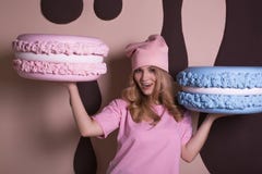 Cheerful blonde model in pink t shirt and cap holding big tasty royalty free stock image Cheerful blonde model in pink t shirt and cap holding big tasty royalty free stock image