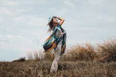 Cheerful boho woman wearing poncho on field Royalty Free Stock Photography Cheerful boho woman wearing poncho on field Royalty Free Stock Photography
