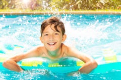 Cheerful boy swimming on air mattress in pool stock images Cheerful boy swimming on air mattress in pool stock images