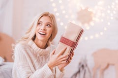 Cheerful curious woman shaking a Christmas box Royalty Free Stock Photos Cheerful curious woman shaking a Christmas box Royalty Free Stock Photos