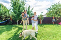 cheerful family with labrador dog spending time together on backyard