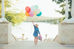 Cheerful Girl Holding Colorful Balloons And Childish Suitcase Stock Photography