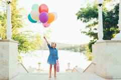 Cheerful Girl Holding Colorful Balloons And Childish Suitcase Royalty Free Stock Photos