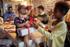 Cheerful girls celebration holiday and giving Christmas present stock photo Cheerful girls celebration holiday and giving Christmas present stock photo
