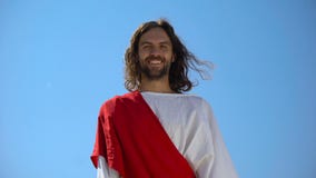 Cheerful god Jesus laughing into camera from heaven, concept to enjoy life