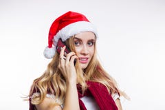 Cheerful happy woman puts on Santa`s red hat and talks on her smartphone. Online shopping, Christmas discounts, gift shopping, stock photo Cheerful happy woman puts on Santa`s red hat and talks on her smartphone. Online shopping, Christmas discounts, gift shopping, stock photo