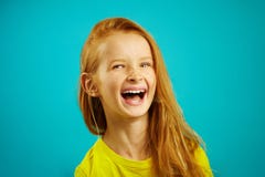 Cheerful little girl laughs a sincere expression of feelings, portrait of happy child on blue background. royalty free stock photos Cheerful little girl laughs a sincere expression of feelings, portrait of happy child on blue background. royalty free stock photos