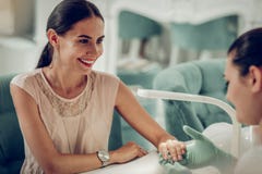 Cheerful long-haired client with bright makeup leaning on table royalty free stock photo Cheerful long-haired client with bright makeup leaning on table royalty free stock photo