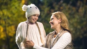 Cheerful mother and daughter looking at each other in autumn park, motherhood stock image Cheerful mother and daughter looking at each other in autumn park, motherhood stock image