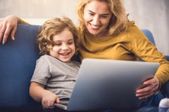 Cheerful mother enjoying exploiting computer with son royalty free stock photo Cheerful mother enjoying exploiting computer with son royalty free stock photo