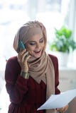 Cheerful Muslim woman smiling while speaking on the phone royalty free stock images Cheerful Muslim woman smiling while speaking on the phone royalty free stock images