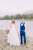 Cheerful newlywed couple is walking along the beach. royalty free stock photography Cheerful newlywed couple is walking along the beach. royalty free stock photography
