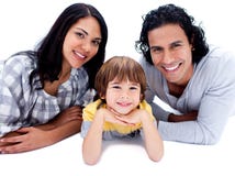 Cheerful parents with their son lying on the floor stock image Cheerful parents with their son lying on the floor stock image