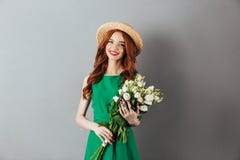Cheerful redhead young woman holding flowers. royalty free stock images Cheerful redhead young woman holding flowers. royalty free stock images
