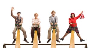 Cheerful senior people having fun on a seesaw stock photography Cheerful senior people having fun on a seesaw stock photography