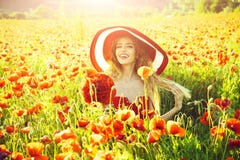 Cheerful woman on a flower field. girl in field of poppy seed in retro hat stock photo Cheerful woman on a flower field. girl in field of poppy seed in retro hat stock photo