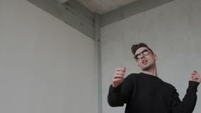 Cheerful young guy is dancing in euphoria. He dancing modern cool choreography alone at home. Passion handsome guy stock footage Cheerful young guy is dancing in euphoria. He dancing modern cool choreography alone at home. Passion handsome guy stock footage