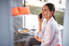 Cheerful young lady talking on the phone while having lunch royalty free stock photo Cheerful young lady talking on the phone while having lunch royalty free stock photo