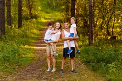 Cheerful young man and woman holding two children in the summer outdoors. family stock image Cheerful young man and woman holding two children in the summer outdoors. family stock image