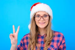 Cheerful young smiling lady in santa hat, checkered shirt and g royalty free stock photo Cheerful young smiling lady in santa hat, checkered shirt and g royalty free stock photo
