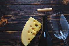 Cheese two bottles of wine and a glass of wooden background space for copy royalty free stock photography Cheese two bottles of wine and a glass of wooden background space for copy royalty free stock photography