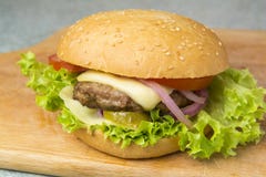 Cheeseburger με το μαρούλι, την ντομάτα, και το κρεμμύδι σε ένα brioche κουλούρι στοκ εικόνες Cheeseburger με το μαρούλι, την ντομάτα, και το κρεμμύδι σε ένα brioche κουλούρι στοκ εικόνες