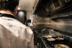 Chef anonyme se tenant sur la cuisine de restaurant photos stock Chef anonyme se tenant sur la cuisine de restaurant photos stock