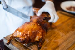 The chef is cutting the duck skin from the Beijing duck with a very sharp knife at a famous Chinese restaurant. stock image The chef is cutting the duck skin from the Beijing duck with a very sharp knife at a famous Chinese restaurant. stock image