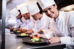 Chef de sourire avec le plat garni de nourriture dans la cuisine photo stock Chef de sourire avec le plat garni de nourriture dans la cuisine photo stock
