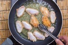 Chef faisant frire des ailes de poulet dans la casserole photographie stock Chef faisant frire des ailes de poulet dans la casserole photographie stock