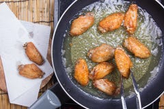 Chef faisant frire des ailes de poulet dans la casserole photo libre de droits Chef faisant frire des ailes de poulet dans la casserole photo libre de droits